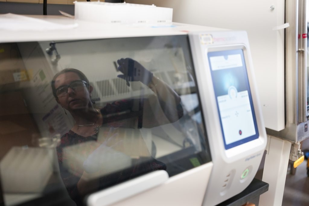 A view of the KingFisher Apex machine cover with a reflection of a person working.