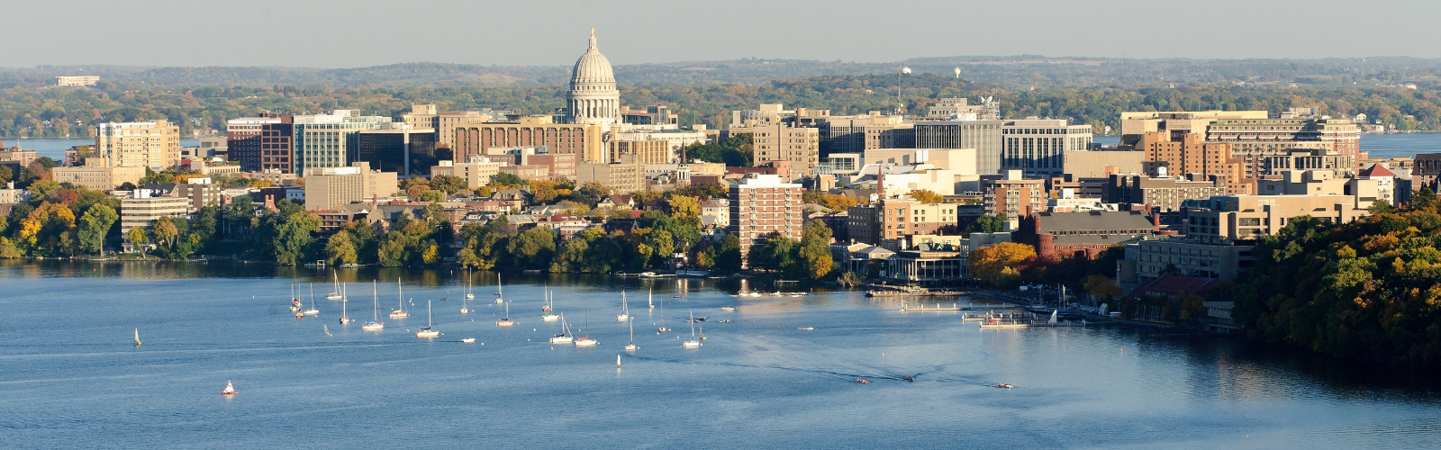 Aerial view of Lake Mendota and downtown Madison with the capitol building and part of the University of Wisconsin Madison campus visible.