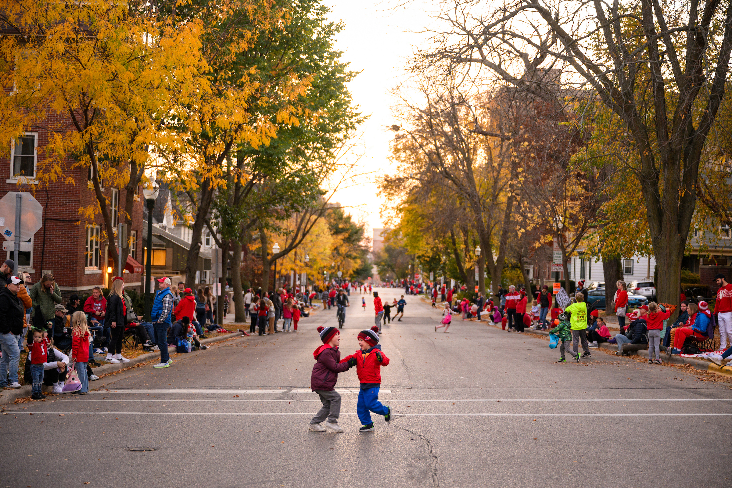 Two children dancing on a street before a parade-Link to Community Resources.