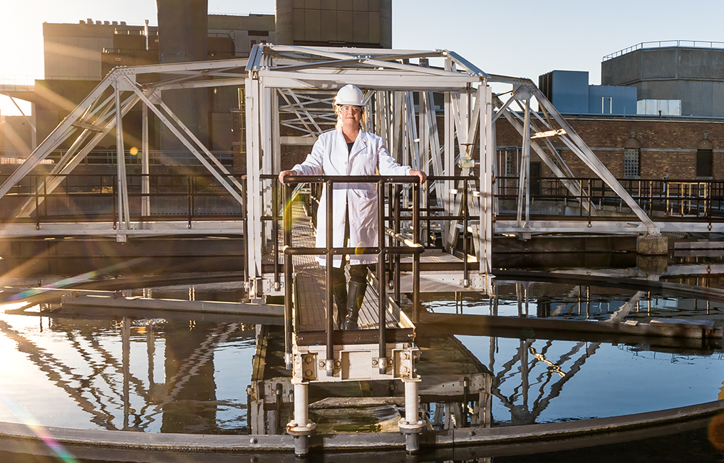 University of Wisconsin Milwaukee professor, Sandra McLellan, standing on a metal walkway above one of the clarifiers at the Milwaukee Metropolitan Sewerage District’s Jones Island treatment facility.